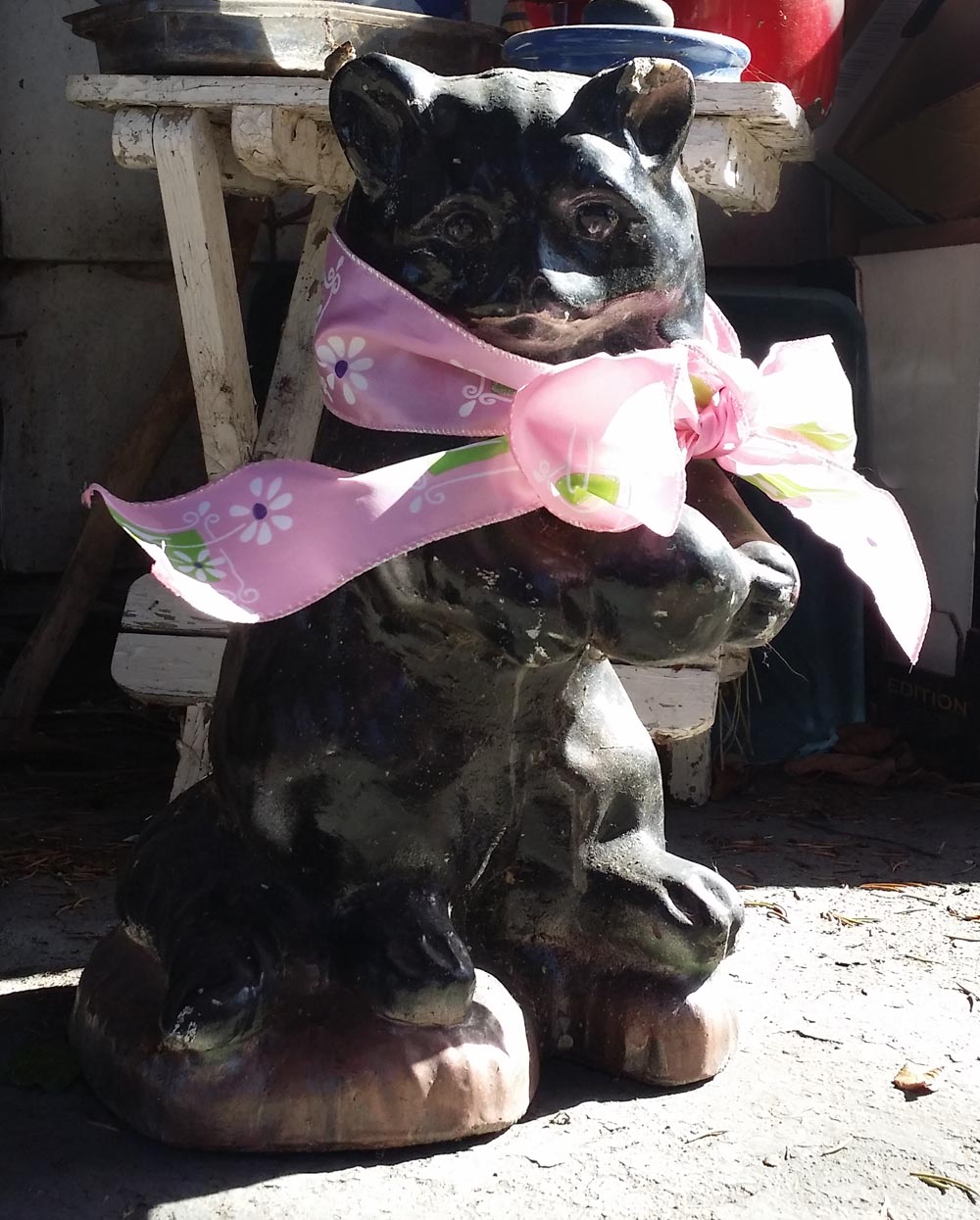 black cat statue with pink bow