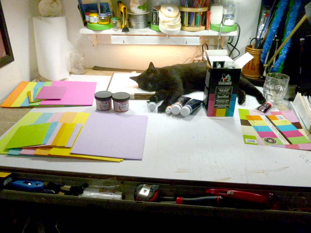 cat and art materials on table