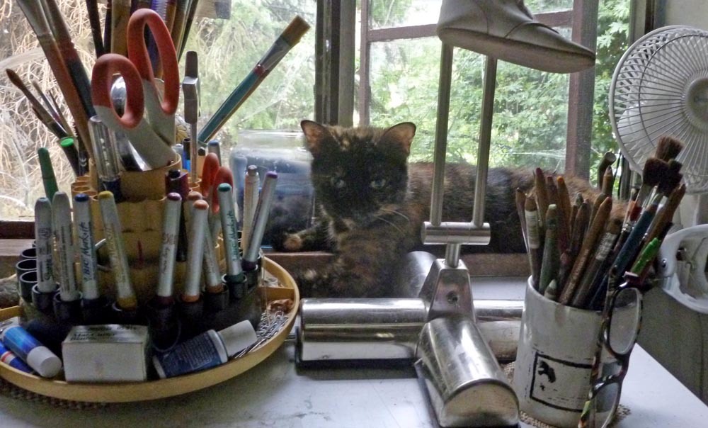 tortoiseshell cat looking at desk