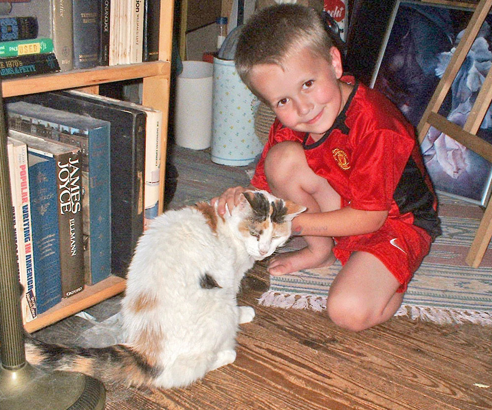 little boy with calico cat