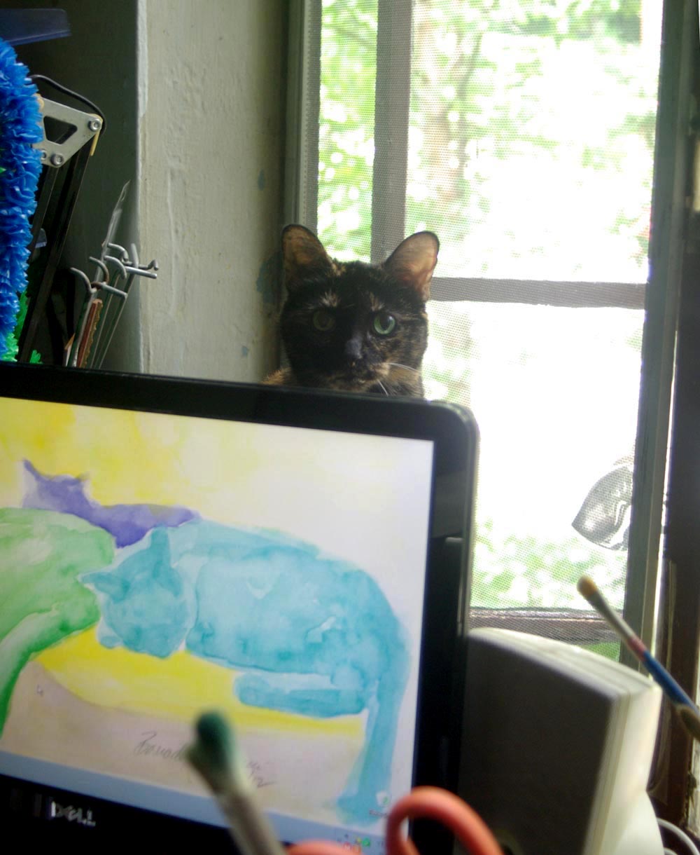 tortoiseshell cat behind computer