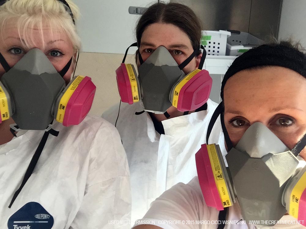 Sydney Bader, Lisa Kalmeyer and Margo Cicci Wisniewski don hazmat suits and respirator masks.