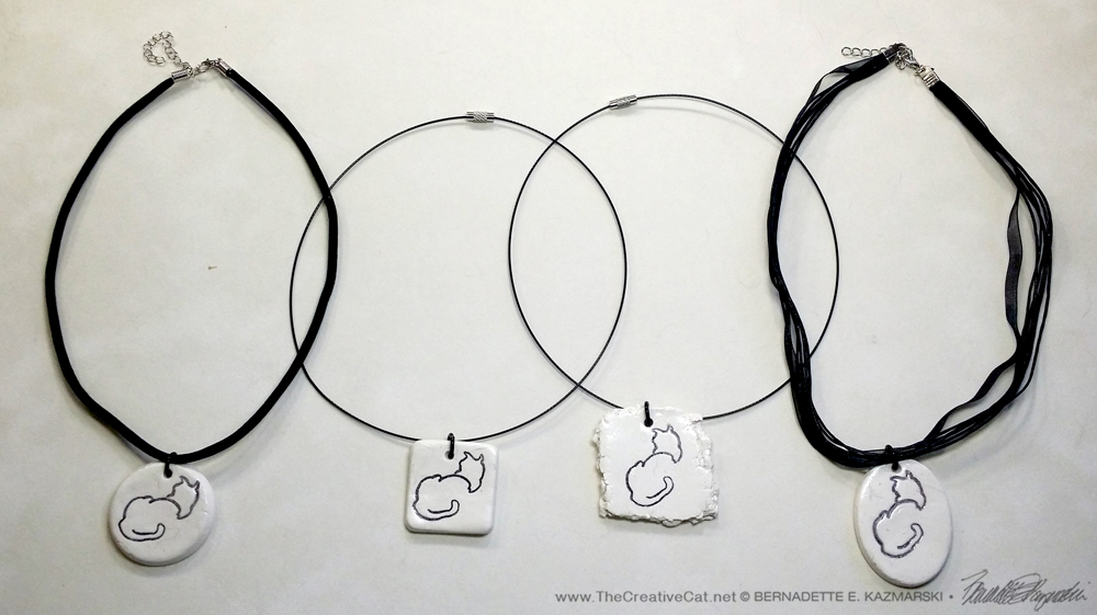 All four pendants”. 1″ x 1″ round on flocked cord; 1″ x 1″ square on wire cord; 1.5″ x 1.5″ random on wire cord; 1″ x 1.5″ oval on multi-strand cord.