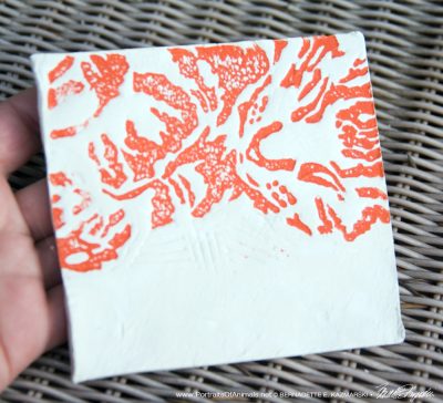 Air-dry clay tile, "Wrinkled Pajamas" in orange.